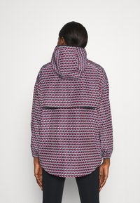Bunt gepolsterte Jacke mit einem geometrischen Muster in Rot, Weiß und Blau. Verfügt über eine große Kapuze und elastische Bündchen, mit einem lässigen Schnitt.