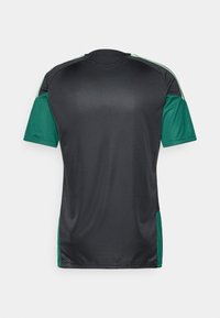 Αθλητικό μπλουζάκι κοντομάνικο σε σκούρο γκρι χρώμα με πράσινες λεπτομέρειες στους ώμους και στα πλάγια, διαθέτοντας στρογγυλή λαιμόκοψη και απαλό, αναπνεύσιμο ύφασμα.