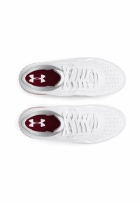 White athletic shoes made of synthetic material featuring a perforated design, flat laces, and a maroon insole with a white logo.
