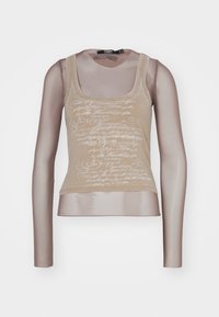 Beige ärmlös topp med en texturerad överlappning, med genomskinliga långa ärmar och ett tryckt mönster som liknar kursiv text.