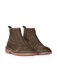 Botas de tobillo de ante marrón con cierre de cremallera, suela de goma plana y costuras decorativas a lo largo del borde. Diseño minimalista con lengüetas para tirar.