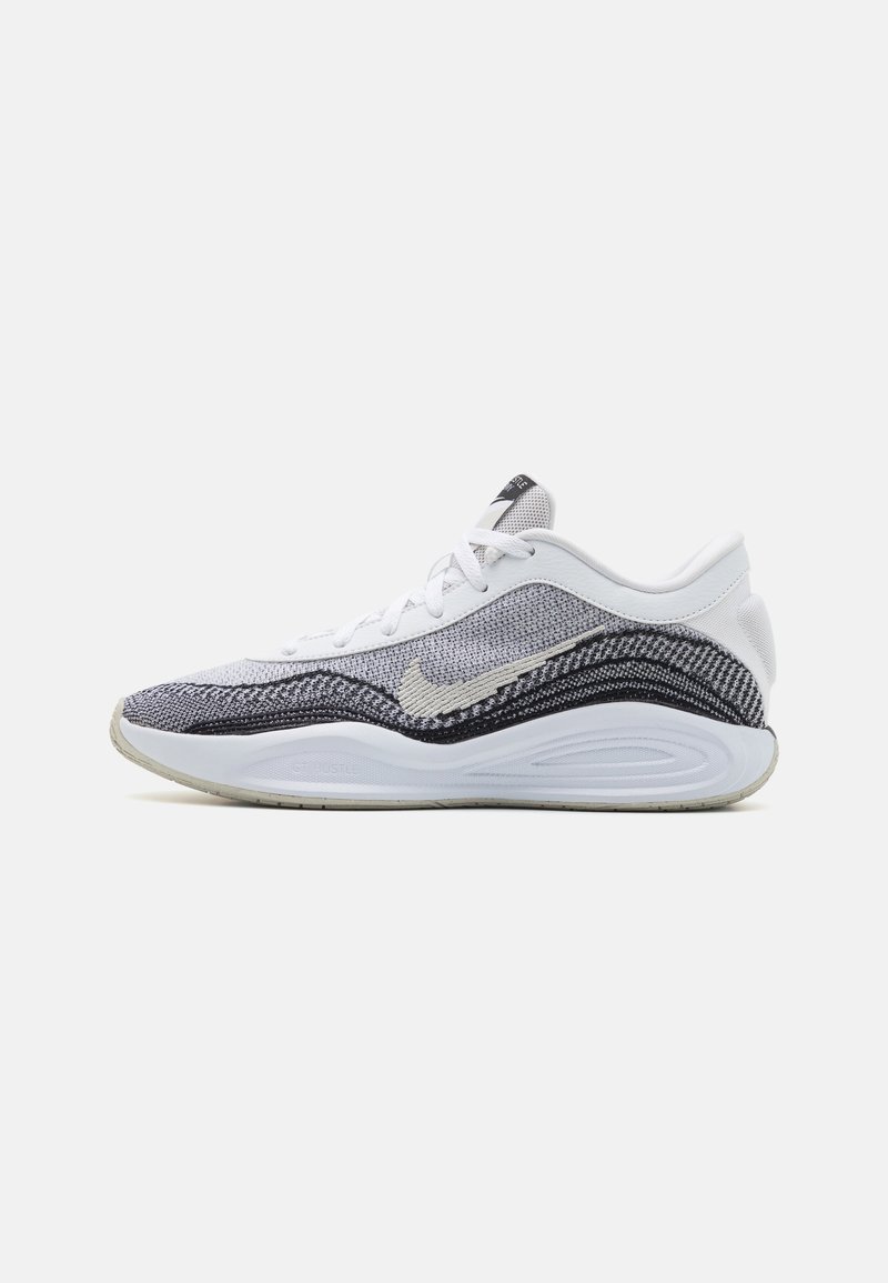 Hvid sneaker med tekstureret grå og sort strikoverdel. Har en rund tå, polstret sål og et fremtrædende Swoosh-logo på siden.