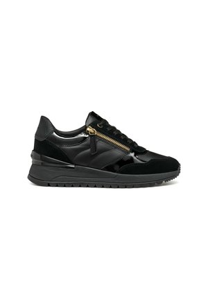 Des sneakers noirs présentant un mélange de textures brillantes et en daim, un col rembourré, une semelle épaisse et un détail décoratif en zip doré sur le côté.
