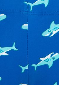 Tecido de natação azul com um padrão repetido de tubarões de desenho animado em azul claro, com detalhes e expressões sorridentes. Textura suave, material elástico.