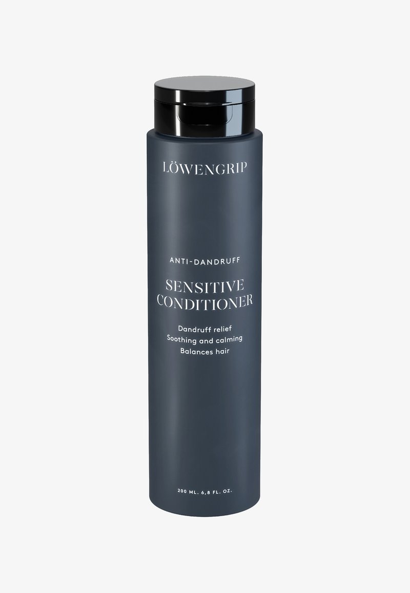 Mørkegrå cylindrisk flaske med en sort låg, mærket "SENSITIV BALSAM" og "ANTI-SKÆF." Indeholder 200 ml produkt.
