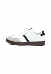 Zapatillas con una parte superior de cuero blanco, puntera de ante gris, franja de acento negra y una suela de goma marrón. Presenta cordones y un collar acolchado.