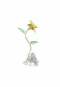 Flor decorativa de vidrio con un tallo de color dorado, que presenta una flor amarilla y dos hojas verdes sobre una base clara, similar al cristal.