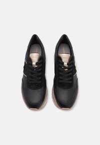Sneaker neri realizzati in una combinazione di pelle e suede, con lacci neri e un accento dorato sul lato. Suola in gomma testurizzata.