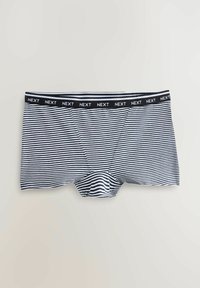 Men's trunk-style underwear in navy and white stripes, featuring a black elastic waistband with "NEXT" logo. Soft fabric and fitted design.