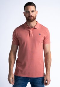 Polo à manches courtes en corail, avec un col et une patte de boutonnage à trois boutons. Petit logo sur la poitrine gauche. Fabriqué en tissu coton lisse.