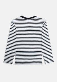 Langermet skjorte med svart og hvit horisontal striping, laget av bomull, rund svart hals, og et enkelt, uformelt design.