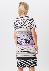 Kurzes Kleid mit kurzem Ärmel und einem gemusterten Design in Schwarz, Weiß und Lila, mit einem floralen Abschnitt und kontrastierenden horizontalen Streifen.