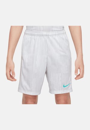 Hvide atletikshorts med subtilt vertikalt "Nike"-tekstmønster og en turkis Nike-swoosh, båret af en person med synlige hænder og knæ.