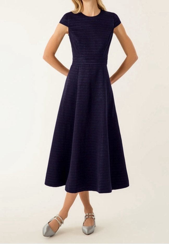 Marinblå, knälång A-linjeformad klänning med korta ärmar, ribbad textur, åtsittande liv och en utsvängd kjol, kombinerad med silverfärgade flats.