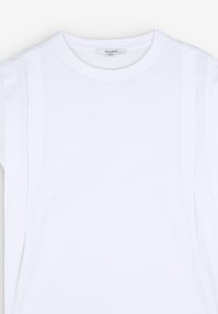 Hvid t-shirt med rund hals, korte ærmer og subtile detaljer ved sidesømmene. Lavet af et glat stof med et enkelt, rent design.
