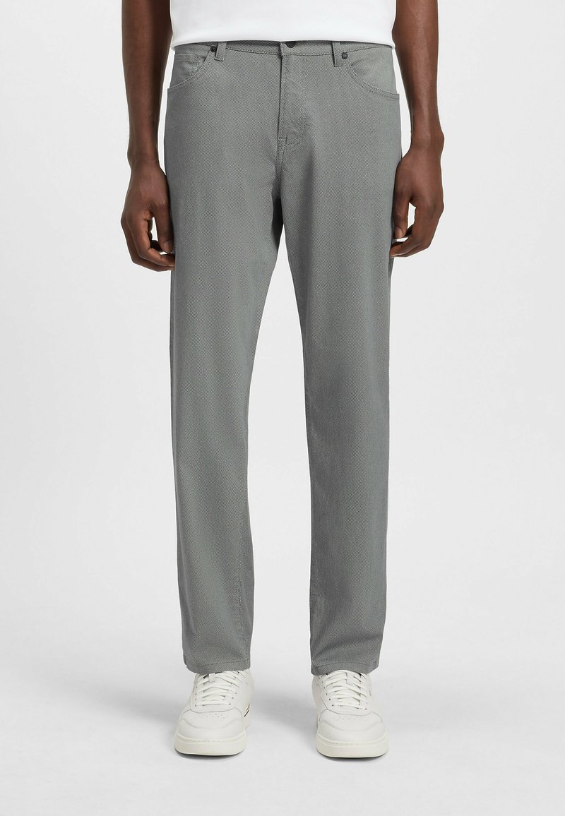 Gray patterned trousers with a straight fit, featuring a waistband with loops and subtle texture, paired with white sneakers.