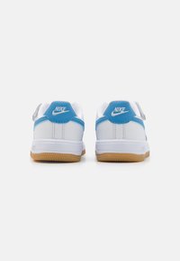 Hvite Nike joggesko med blå detaljer og såle av gummigummi. Har en polstret krage og hæltab med fremtredende logodetaljer.