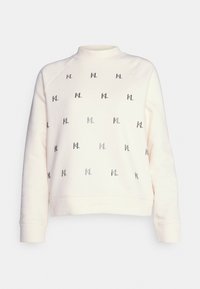 Světle krémová mikina s dlouhými rukávy, vysokým výstřihem a opakujícím se černým logem "KL" po celé přední části.