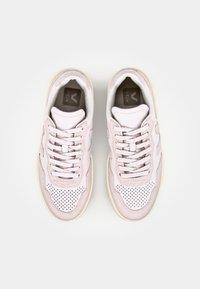 Baskets rose clair avec une texture en cuir lisse, un design perforé et des lacets blancs, dotées d'une semelle en caoutchouc beige et d'un logo sur la languette.