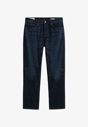 Σκούρο μπλε τζιν με ίσια γραμμή, πέντε τσέπες και ορατά ραφές, τοποθετημένα επίπεδα σε λευκό φόντο.