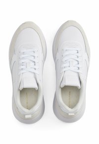 Białe sportowe sneakersy z gładkiej skóry, z zamszowymi akcentami i masywną gumową podeszwą. Sznurowadła przeplatane są przez wzmocnione oczka.