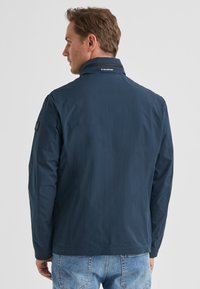 Marineblaue, leichte Jacke mit Stehkragen, Rücklogo und minimalen Nähten. Verfügt über lange Ärmel und ein gerades Schnittdesign.