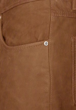 Ruskea nahkakangas, jossa on lähikuva taskusta, jossa näkyy tikkaus ja hopeinen napitusyksityiskohta. Pinta on sileä ja matta.