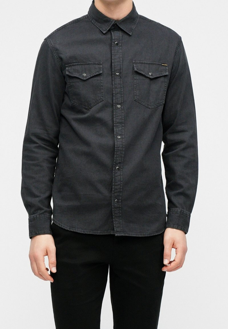 Dark gray denim shirt with a button-down collar, two chest pockets, and metallic buttons. Long sleeves with buttoned cuffs.