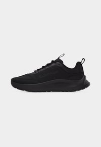 Baskets basses noires Calvin Klein avec lacets à l’avant, languettes sur la languette et le talon, et semelle épaisse et rembourrée, vues de côté.