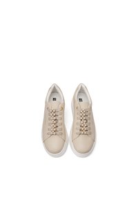 Sneakers in pelle beige con lacci piatti, decorate con una fila di gemme trasparenti lungo la linguetta. Suola in gomma bianca; design minimalista.