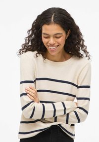 Beżowy sweter w granatowe paski, z okrągłym dekoltem, długimi rękawami, prążkowanymi mankietami i luźnym krojem. Miękki materiał o teksturowanym wykończeniu.