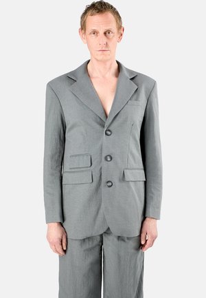 Grau suit aus strukturiertem Stoff mit einem einreihigen Design, lappengeschlagenem Revers, zwei Fronttaschen und drei Knöpfen. Die Hose passt zur Jacke.