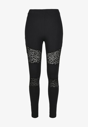 Fekete leggings áttetsző leopárdmintás panelek a combnál és az alsó lábszáraknál. Simává varrott anyag, testhezálló fazon, rugalmas derékpánt.