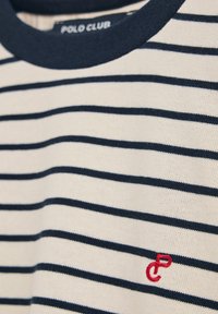 Pasiasta bawełniana koszulka z granatowo-białymi poziomymi paskami, z granatowym okrągłym dekoltem i małym czerwonym haftowanym logo na piersi.