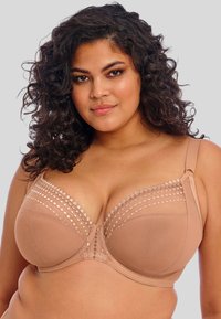 Nude bralette met een gladde stof, kantdetails aan de bovenkant en brede schouderbanden. Met beugelsteun en decoratieve accenten.