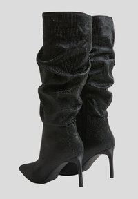 Stivali neri al ginocchio con una superficie texturizzata, caratterizzati da arricciature, punte affusolate e tacchi a stiletto, con chiusura con zip posteriore.