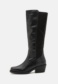 Svarta knähöga stövlar med slät läder och mjuka mockadetaljer, rundad tå och en låg blockklackdesign.