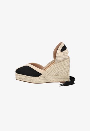Zapato espadrille de cuña con parte superior de lona en negro y beige, suela de cuerda trenzada y cinta beige con cuadros para el tobillo con lazada negra.