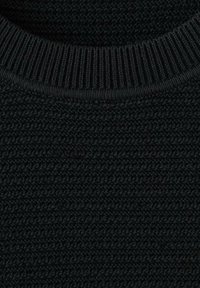 Primo piano di un tessuto lavorato a maglia nero con motivo testurizzato e scollo a coste, che mette in risalto il materiale e i dettagli delle cuciture del maglione.