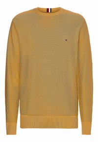 Maglione giallo lavorato a maglia con polsini e orlo a coste, colletto rotondo e piccolo logo sul petto. Tessuto testurizzato con motivo delicato.