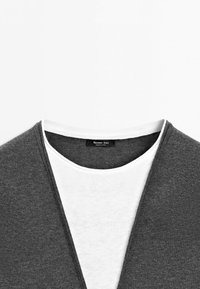 Collar view of a gray outer garment layered over a white inner shirt with a visible Massimo Dutti brand label.