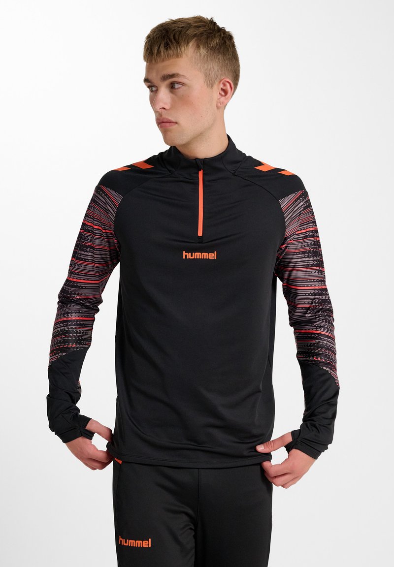 Svart träningspullover med en fjärdedel dragkedja, med mångfärgade mönstrade ärmar och logotyp. Tillverkad av lätt, elastiskt material.