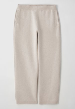 Pantaloni de trening bej dintr-un material moale, cu un talie lată, buzunare laterale și picioare îngustate pentru un fit lejer.