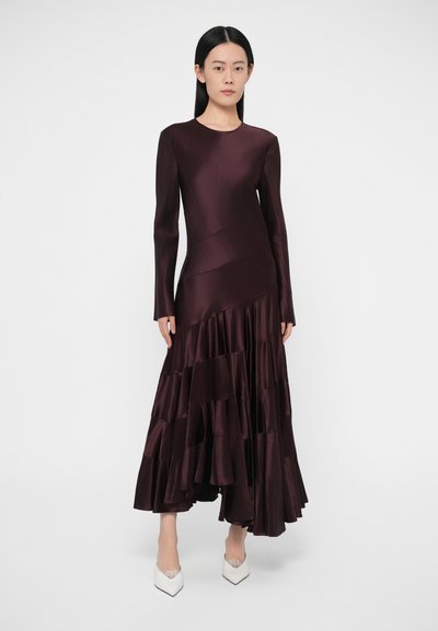 Obleka iz globoko bordo barve iz satena z dolgimi rokavi, slojevito volanasta na robu, z oprijetim zgornjim delom in gladko teksturo.