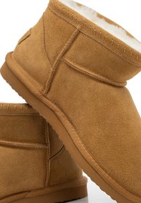 Stivaletti alla caviglia in camoscio color cuoio con fodera interna morbida, dettagli cuciti e suola in gomma con fondo testurizzato per una migliore presa.