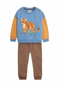 Kék pulóver tigris grafikával, barna ujjakkal és kerek nyakkivágással. Barna nadrág oldalsó zsebekkel és rugalmas mandzsettával. Puha anyagból készült.