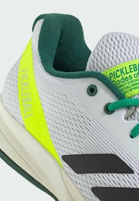 Scarpa da ginnastica bianca e verde con striscia neon gialla "PICKLEBALL", tomaia in rete, fodera verde e lacci verdi.