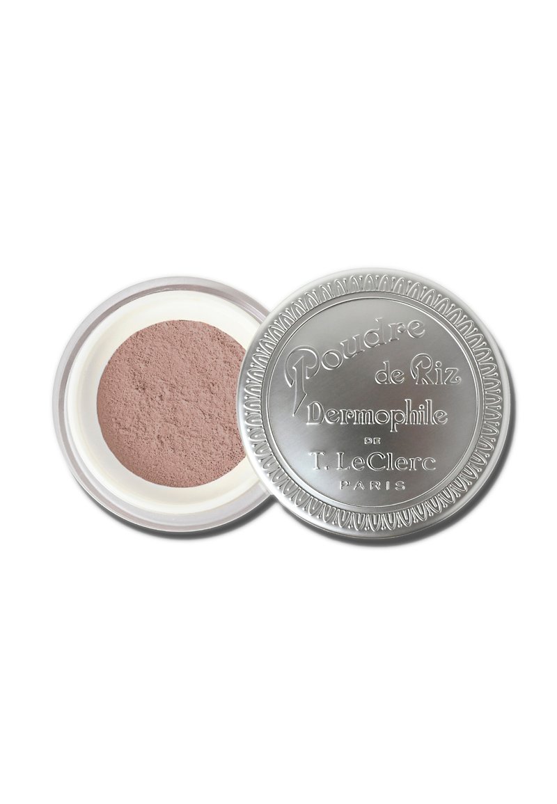 Contenitore cosmetico rotondo in argento con lettering impresso, contenente una polvere translucida di colore rosa chiaro. Superficie liscia, sigillato con un coperchio trasparente.