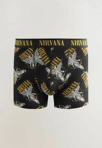 Shorts en coton noirs avec un imprimé graphique Nirvana en gris et jaune, dotés d'une ceinture logo jaune pour plus de détails.