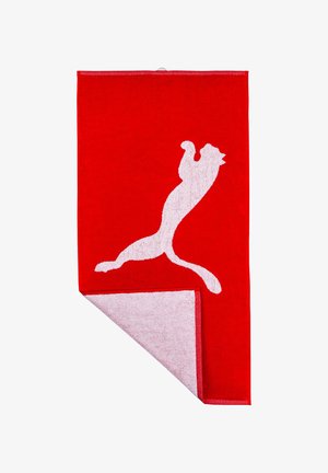Red towel made of terry cloth featuring a white jumping cat silhouette and a contrasting white border on one edge. Soft texture.